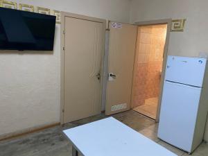 a kitchen with a white refrigerator and a television at Адмирал хостел in Odesa