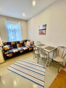 a living room with a table and chairs and a couch at ''Rozā namiņš'' in Ventspils