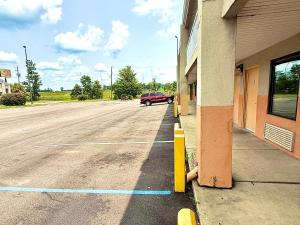 a parking lot next to a building with a red car at Magnolia Inn Townhouse Hattiesburg MS I-59 in Hattiesburg