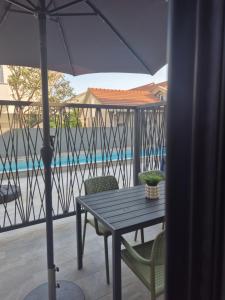 a table and chairs with an umbrella on a balcony at Lux Studio Porto in Tivat