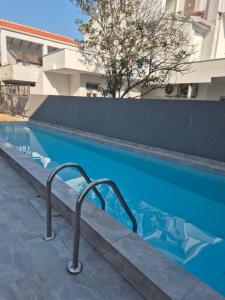 a swimming pool with a hand rail next to a building at Lux Studio Porto in Tivat