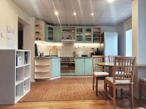 a kitchen with blue cabinets and a table and chairs at 3-room homey apartment in Kärdla in Kärdla
