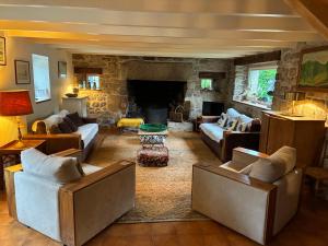 a living room with couches and a stone fireplace at Belle villa en bord de mer à 700 m d'une plage de sable fin in Combrit