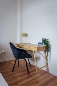 a wooden desk with a blue chair next to it at Stilvolles Altstadt-Apartment mit Parkplatz - Ruhig & Zentral in Celle