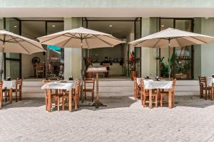 a group of tables and chairs with umbrellas at Florita 39 Boutique Hotel Breakfast & Beach Club Included in Isla Mujeres