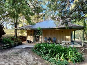 a cabin in the woods with a table and chairs at Kalimna Woods Cottages in Lakes Entrance