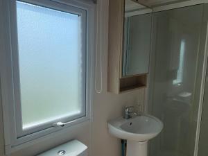 a bathroom with a sink and a window and a toilet at Trenance in Newquay +18 photos