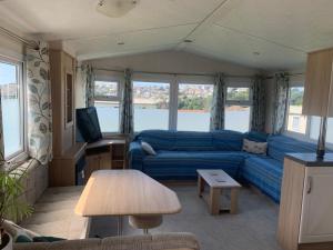 a living room with a blue couch and a table at Trenance in Newquay