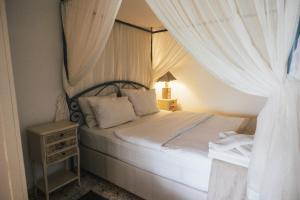 a bedroom with a canopy bed with white curtains at Park Mandalin Hotel - Adult only in Ağva