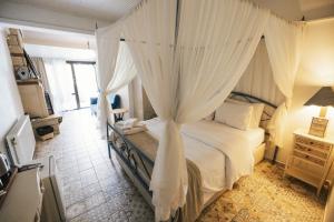 a bedroom with a canopy bed with white curtains at Park Mandalin Hotel - Adult only in Ağva