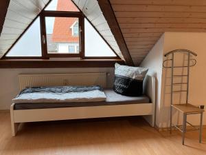 a bed sitting in a room with a window at Monteur Budget-Ferienhaus in Oggelshausen am Federsee nähe Biberach in Oggelshausen