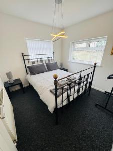 a bedroom with a large bed with a black frame at Millhouse 55 in Risca +14 photos