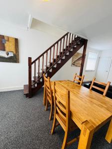a dining room with a wooden table and chairs at Millhouse 55 in Risca