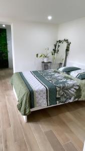 a bed with a quilt on it in a room at La jungle in Saint-Nicolas-dʼAliermont