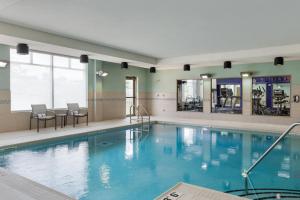 une piscine avec de l'eau bleue dans un immeuble dans l'établissement Holiday Inn Express & Suites Ottawa East-Orleans by IHG, à Ottawa
