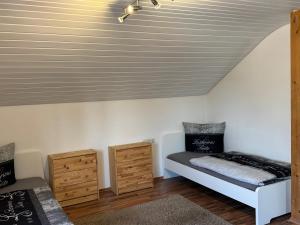 a room with a bed and two dressers at Monteur Budget-Ferienhaus in Oggelshausen am Federsee nähe Biberach in Oggelshausen