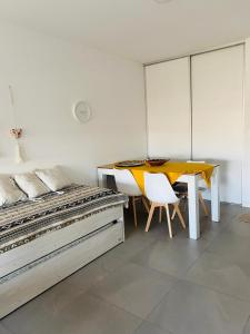 Un dormitorio con una cama y una mesa y sillas. en Monoambiente frente al río en Ramallo, en Ramallo