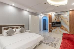 a bedroom with a large white bed and a tv at شقق ابحر المفروشه in Jeddah
