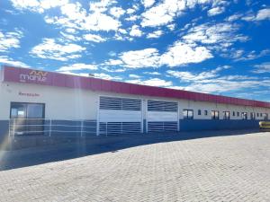 a large white building with a red roof at Mahle Hotel 71 - Área rural entre Jataí e Mineiros in Mineiros
