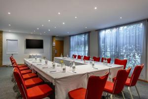 a conference room with a long table and red chairs at Best Western Nairobi Upper Hill in Nairobi