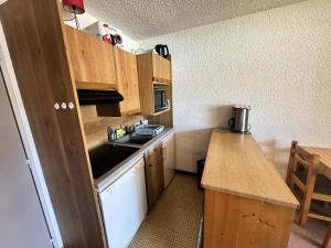 a small kitchen with wooden cabinets and a sink at Résidence La Piscine - Résidence proche du centre de Villard de Lans, à proximité du parc de luge de la Colline des Bains MAE-5693 in Villard-de-Lans