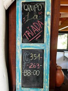 a chalkboard sign on the side of a door at Cabaña La Triada Pileta Privada Grupo Cabaña La Triada in Río Ceballos
