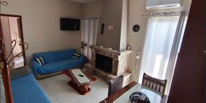 a living room with a blue couch and a fireplace at Nina's Cozy Home in Chrani