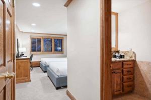 a bedroom with a bed and a bathroom with a sink at Lodge Tower 283 in Vail
