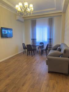 a living room with a couch and a table and chairs at Boulevard Sumgait in Sumqayyt