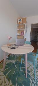 a table with a laptop and two chairs in a room at Incroyable Vue mer et Notre Dame in Marseille