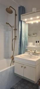 a white bathroom with a sink and a shower at Incroyable Vue mer et Notre Dame in Marseille +31 photos