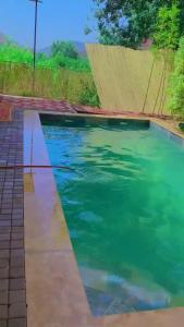 a swimming pool with green water in a yard at Ourika Atlas vu panoramique avec piscine privée in Marrakech
