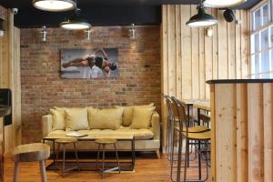 a living room with a couch and a brick wall at The Tilman in Barmouth