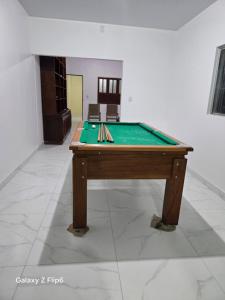 a pool table with cue sticks on top of it at Casa charmosa em Marituba in Marituba