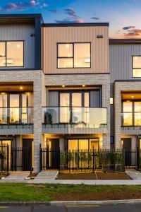 uma imagem de um edifício com um pôr do sol em Lakewalk Retreat Luxe 3BR Home Near Lake and Beach em Auckland