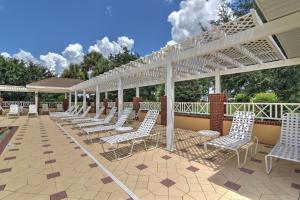 a row of white chairs on a patio at New Designer Home in The Villages Shady Brook in Wildwood