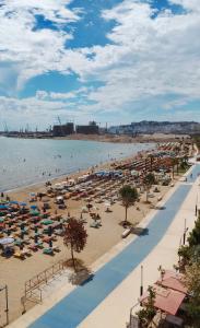 una playa con sombrillas y gente en el agua en Villa Cimi Subashi Seaside Boutique Hotel, en Durrës