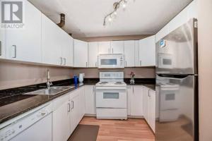 カルガリーにある2-Storey Condo in The Fortress with Pool, Gym, WiFi, Parkingのキッチン(白いキャビネット、白い電化製品付)