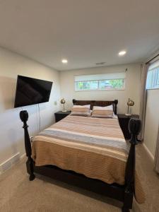 a bedroom with a large bed and a flat screen tv at Skiing, 2 Kitchens, 2 Units in 1, 80in TVs, WD, 2 Backyards in Salt Lake City
