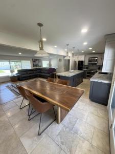 a kitchen and living room with a wooden table at Skiing, 2 Kitchens, 2 Units in 1, 80in TVs, WD, 2 Backyards in Salt Lake City