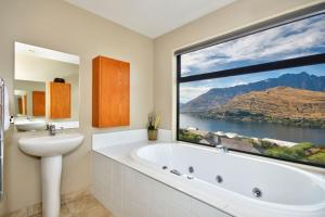a bathroom with a tub and a sink and a large window at Lakeview Lodge Two with Stunning Views in Queenstown +21 photos
