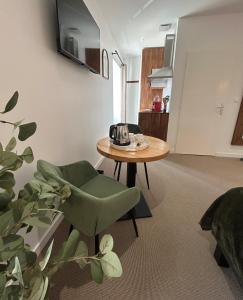 ein Wohnzimmer mit einem Tisch und einem grünen Stuhl in der Unterkunft Quai 44 in Cognac