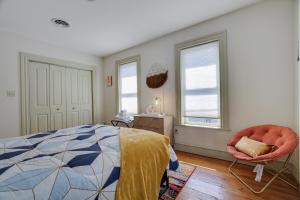 um quarto com uma cama, uma cadeira e janelas em In The Heart Of Jim Thorpe (with your own parking) em Jim Thorpe