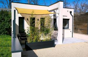 a white house with a yellow awning on it at L'escapade étoilés in Andancette
