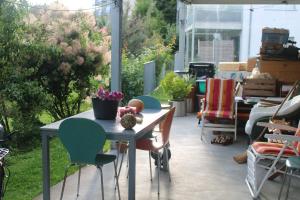 a patio with a table and chairs and plants at Beautiful 14 m2 room in Wünnewil
