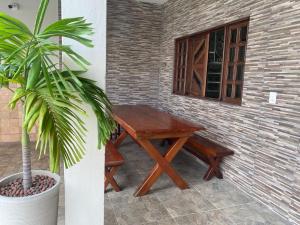 a wooden table and bench next to a window at Casa em Marechal Deodoro in Marechal Deodoro
