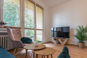 a living room with a couch and a tv and a table at Apartament HoliStay in Oświęcim