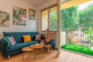 a living room with a green couch and a table at Apartament HoliStay in Oświęcim