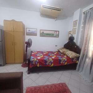 a bedroom with a bed with a comforter and a fan at كيرس in Banī Ghālib