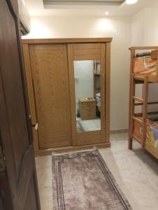 a room with a wooden closet with a mirror at شاليه بجولف بورتو مارينا للأسر فقط in El Alamein